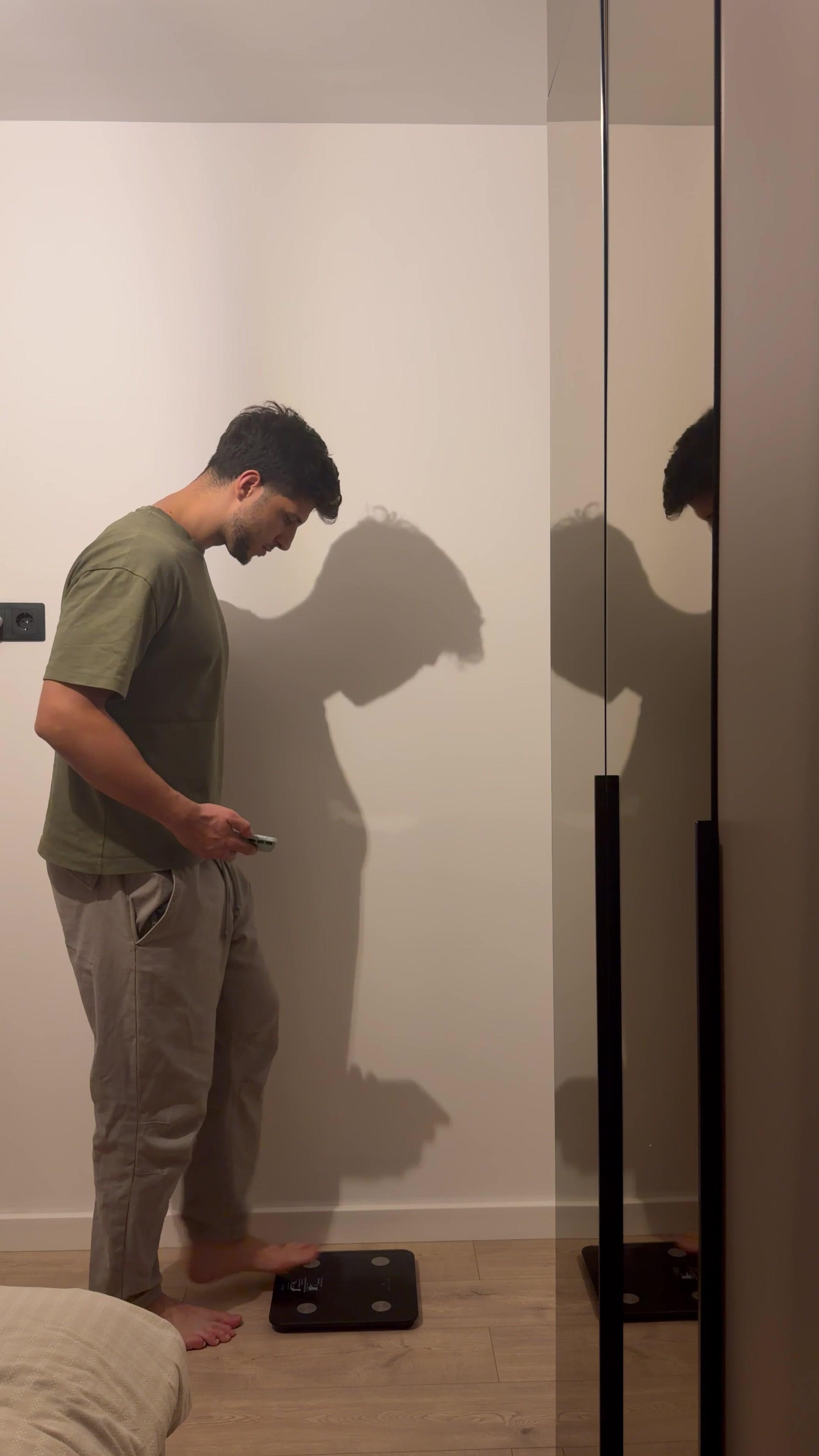 Man Stepping On Smart Scale With Phone